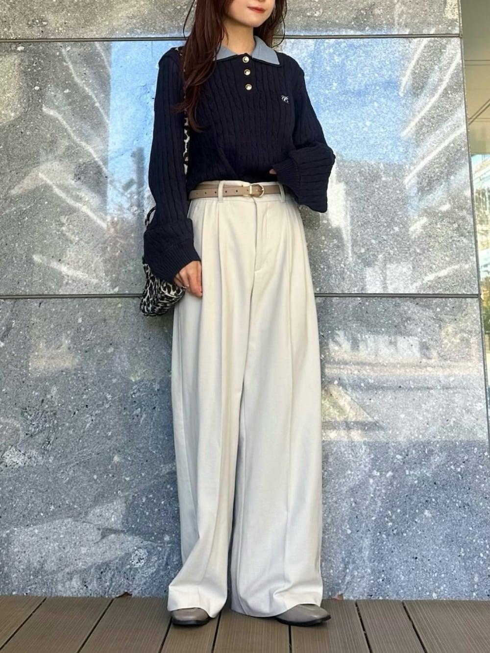 ブルー系のニット/セーター、グレー系のローファー、ブラック系のショルダーバッグを着用したレディースの冬コーディネートの2枚目の写真