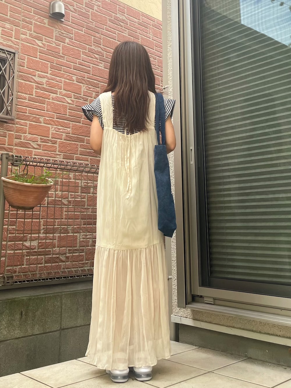 ホワイト系のサンダル、ブラック系のTシャツ/カットソー、ホワイト系のワンピースを着用したレディースの夏コーディネートの3枚目の写真