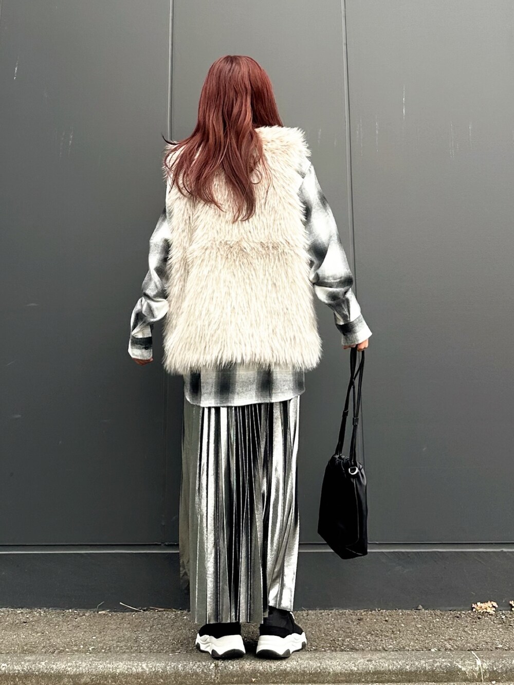 ベージュ系のベスト、ブラック系のスリッポン、ホワイト系のシャツ/ブラウスを着用したレディースの秋コーディネートの4枚目の写真