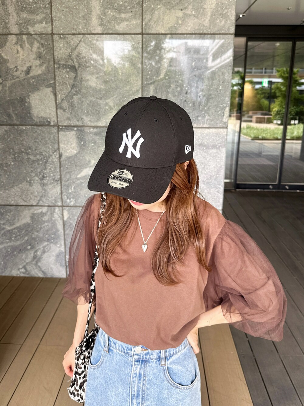 ブラウン系のTシャツ/カットソー、ブルー系のスカート、ブラック系のショルダーバッグを着用したレディースの夏コーディネートの3枚目の写真