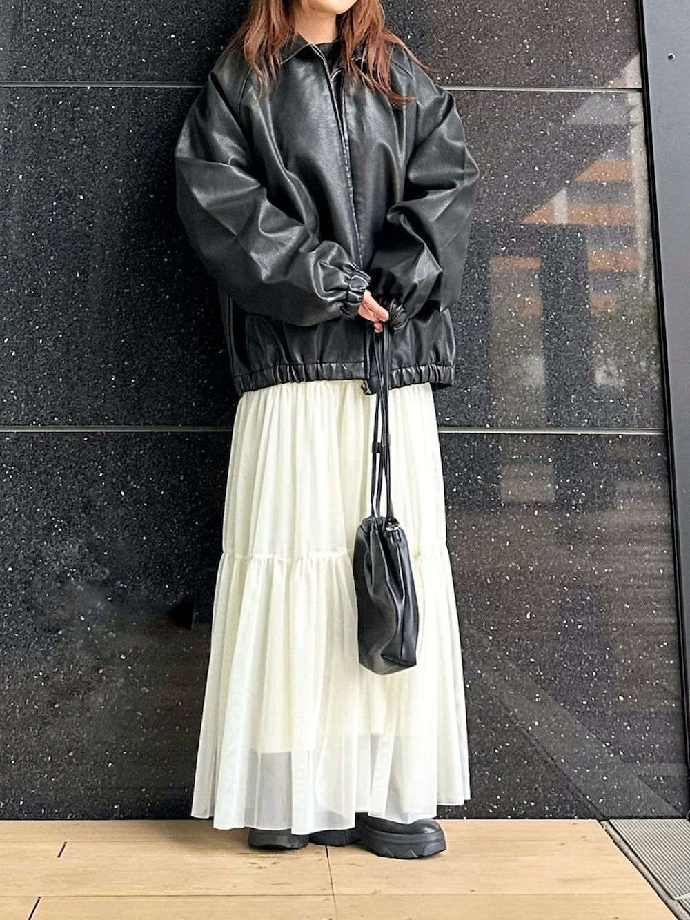 ブラック系のブルゾン、ブラック系のショルダーバッグ、ブラック系のブーツを着用したレディースの冬コーディネートの2枚目の写真