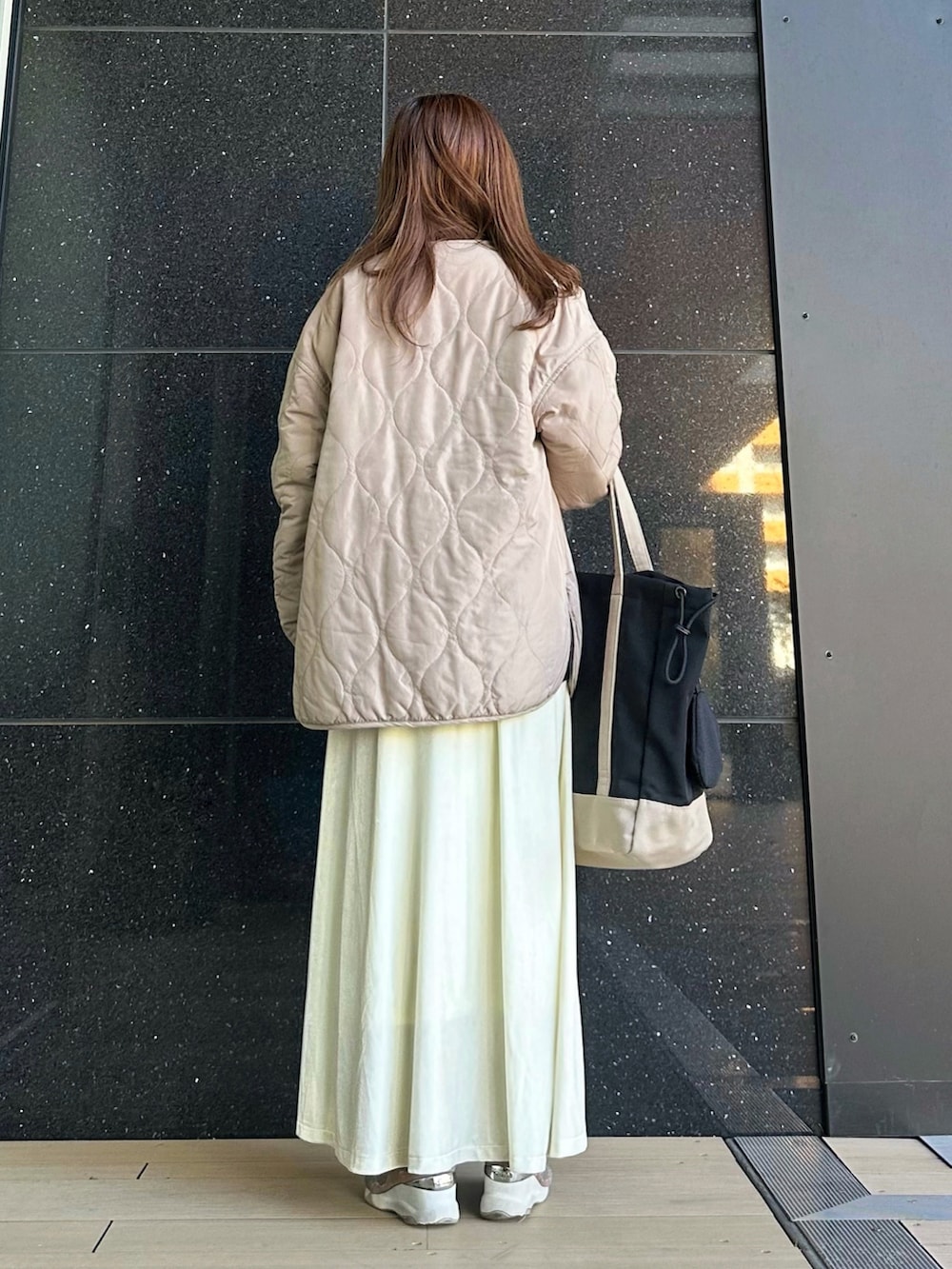 ブラック系のトートバッグ、ブルー系のスウェット、ベージュ系のシャツ/ブラウスを着用したレディースの冬コーディネートの3枚目の写真