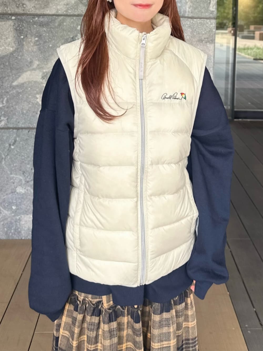 ブルー系のスウェット、ホワイト系のダウンベスト、イエロー系のスカートを着用したレディースの秋コーディネートの3枚目の写真