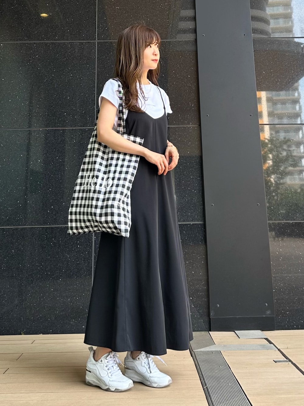ホワイト系のTシャツ/カットソー、ブラック系のワンピース、ブラック系のトートバッグを着用したレディースの春コーディネートの2枚目の写真
