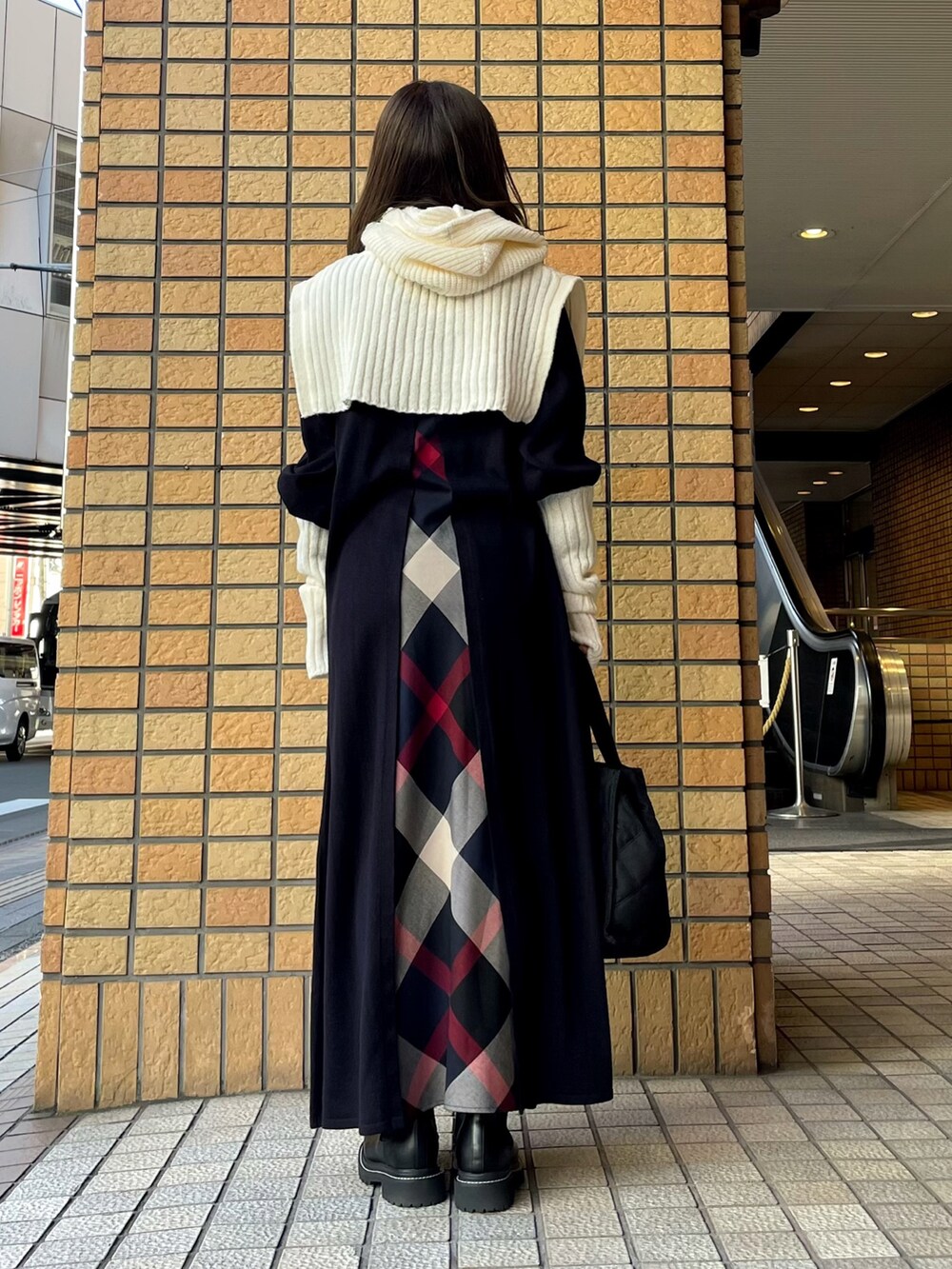 ブルー系のワンピース、ブラック系のトートバッグ、ブラック系のブーツを着用したレディースの冬コーディネートの3枚目の写真