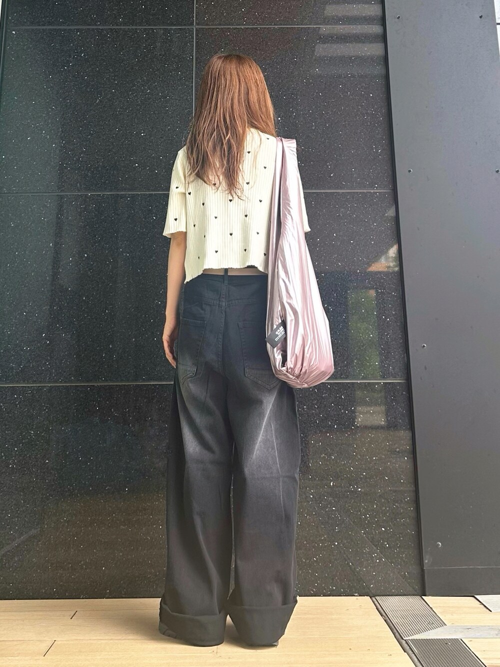 ブラック系のデニムパンツ、ホワイト系のニット/セーター、ブラック系のキャミソールを着用したレディースの夏コーディネートの3枚目の写真