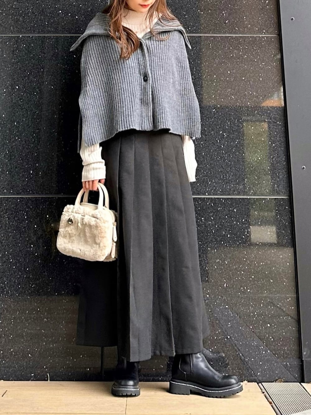 ベージュ系のニット/セーター、ブラック系のブーツ、ブラック系のスカートを着用したレディースの秋コーディネートの3枚目の写真