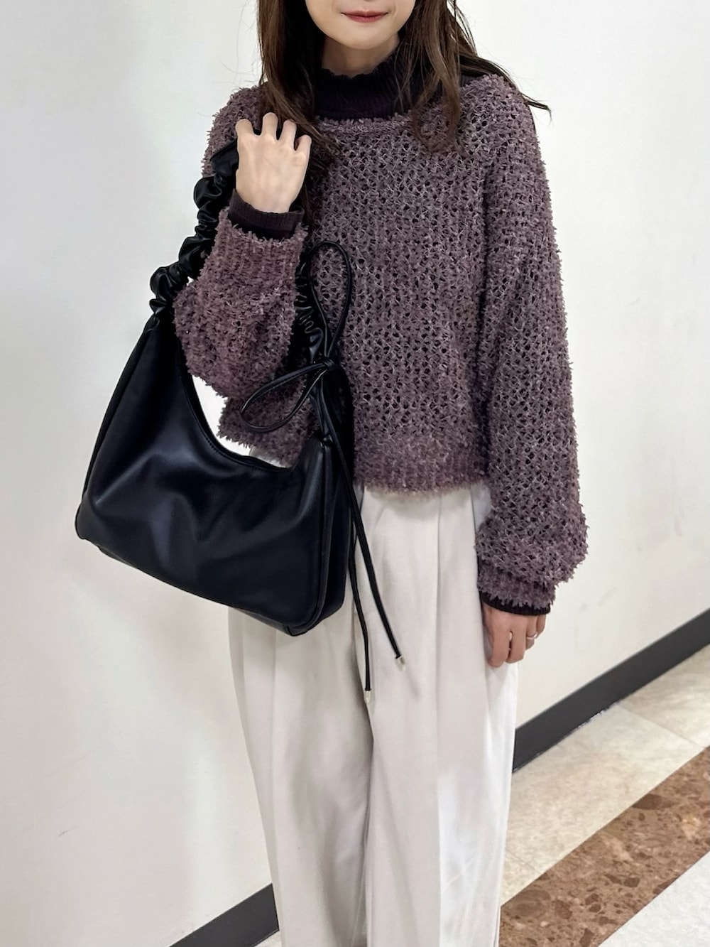 ブラック系のショルダーバッグ、ブラウン系のワンピース/ドレス、ブラウン系のTシャツ/カットソーを着用したレディースの冬コーディネートの4枚目の写真