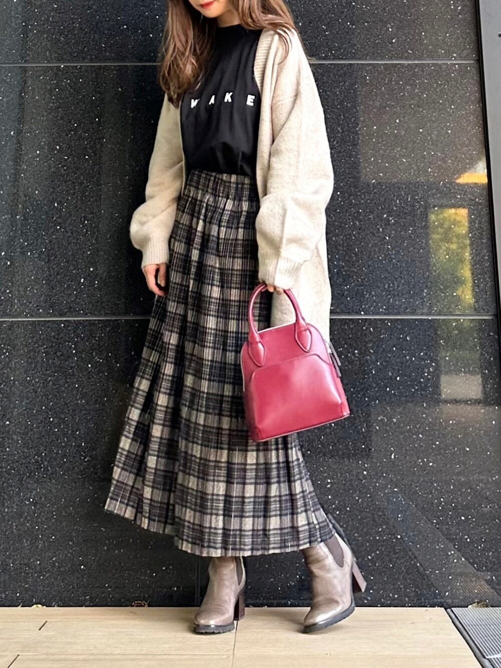 ベージュ系のカーディガン/ボレロ、ブラック系のTシャツ/カットソー、ブラック系のスカートを着用したレディースの秋コーディネートの2枚目の写真