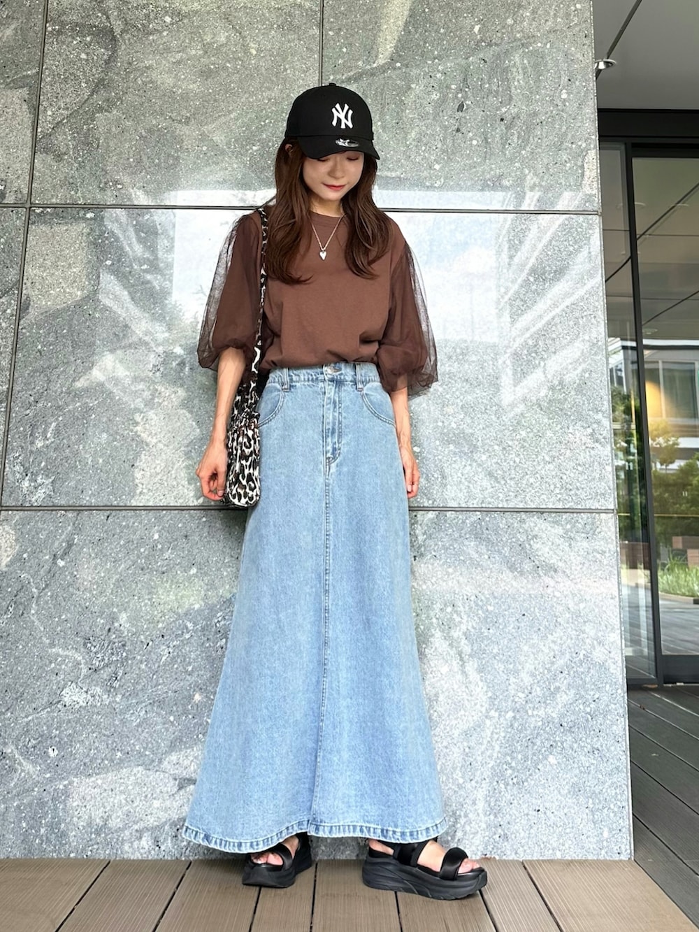 ブラウン系のTシャツ/カットソー、ブルー系のスカート、ブラック系のショルダーバッグを着用したレディースの夏コーディネートの2枚目の写真