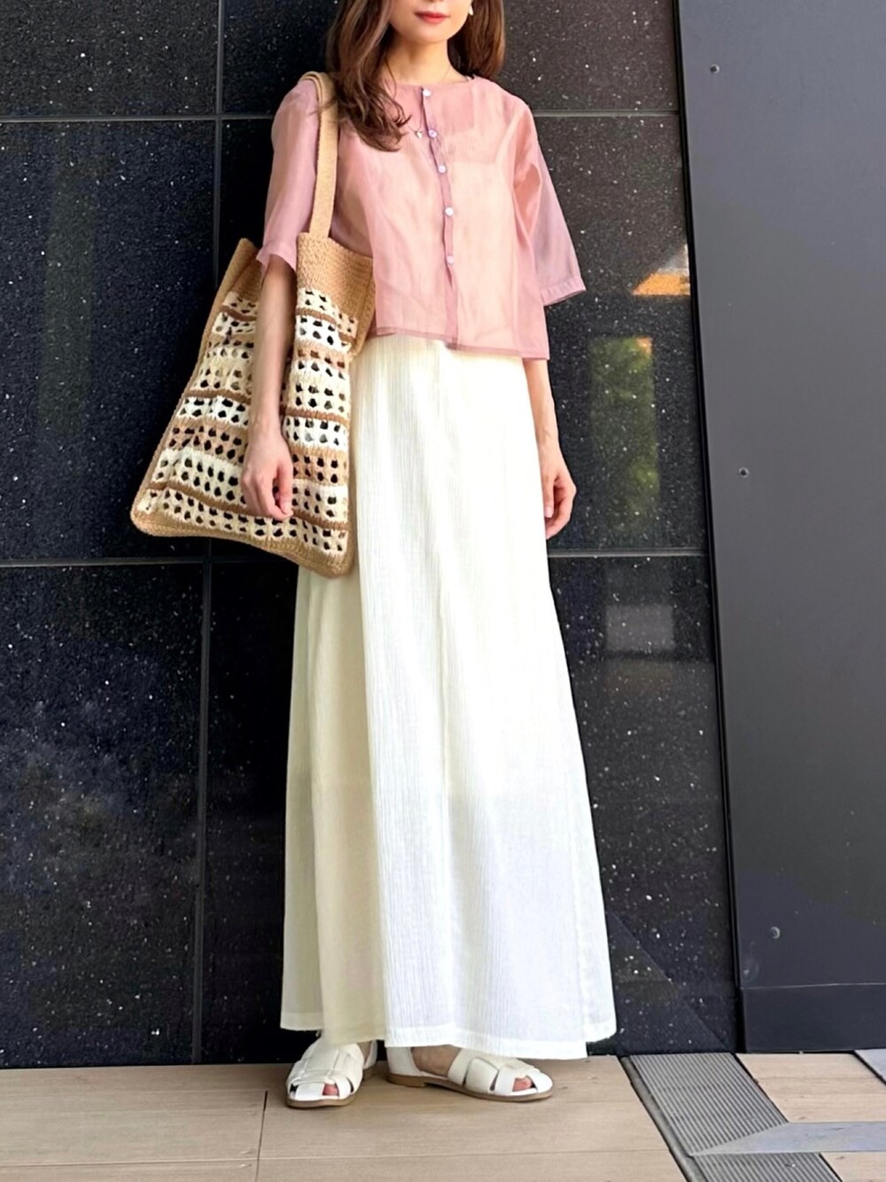 ピンク系のシャツ/ブラウス、ホワイト系のワンピース、ベージュ系のトートバッグを着用したレディースの春コーディネートの2枚目の写真