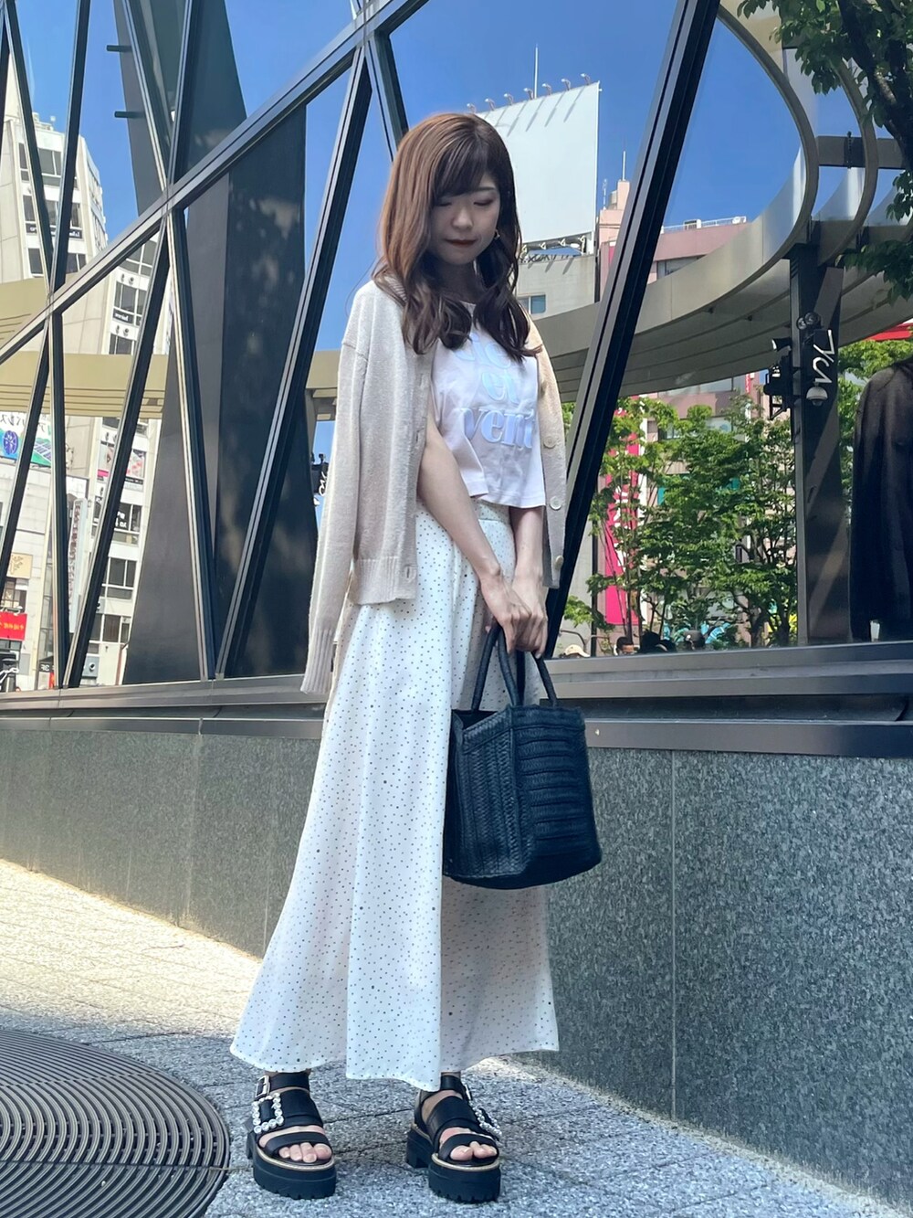 ピンク系のTシャツ/カットソー、ホワイト系のスカート、ブラック系のかごバッグを着用したレディースの春コーディネートの3枚目の写真