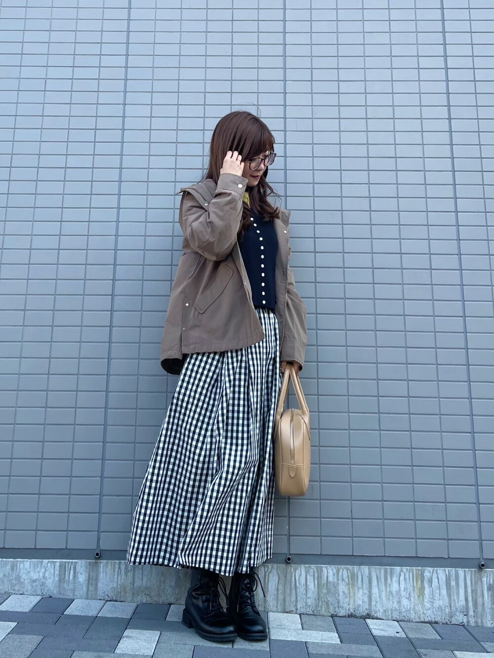 ブラック系のカーディガン/ボレロ、ブラック系のスカート、ベージュ系のショルダーバッグを着用したレディースの春コーディネートの2枚目の写真