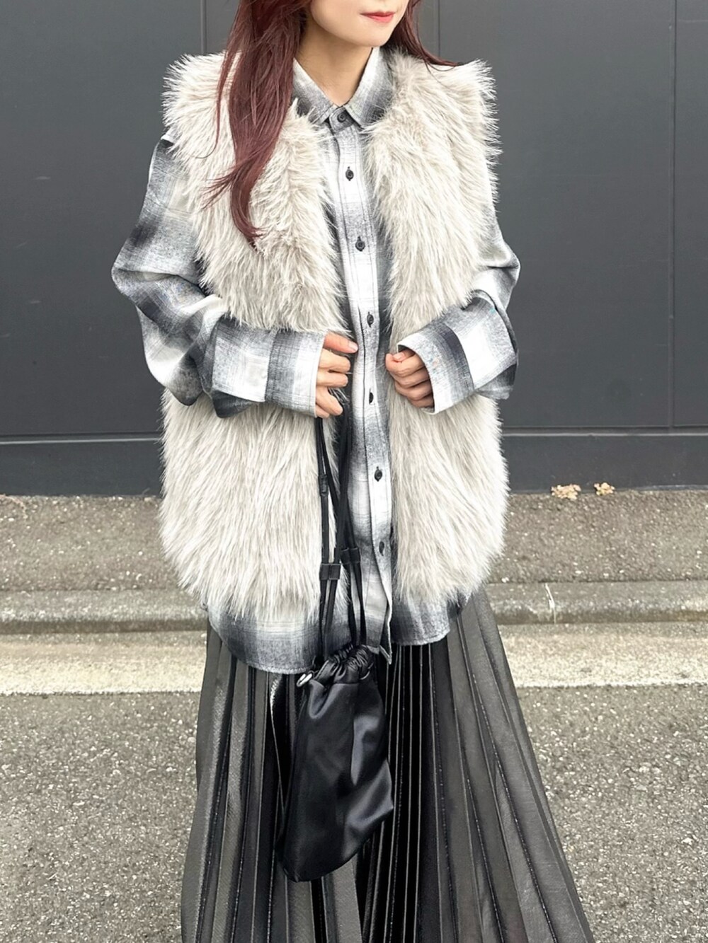 ベージュ系のベスト、ブラック系のスリッポン、ホワイト系のシャツ/ブラウスを着用したレディースの秋コーディネートの3枚目の写真