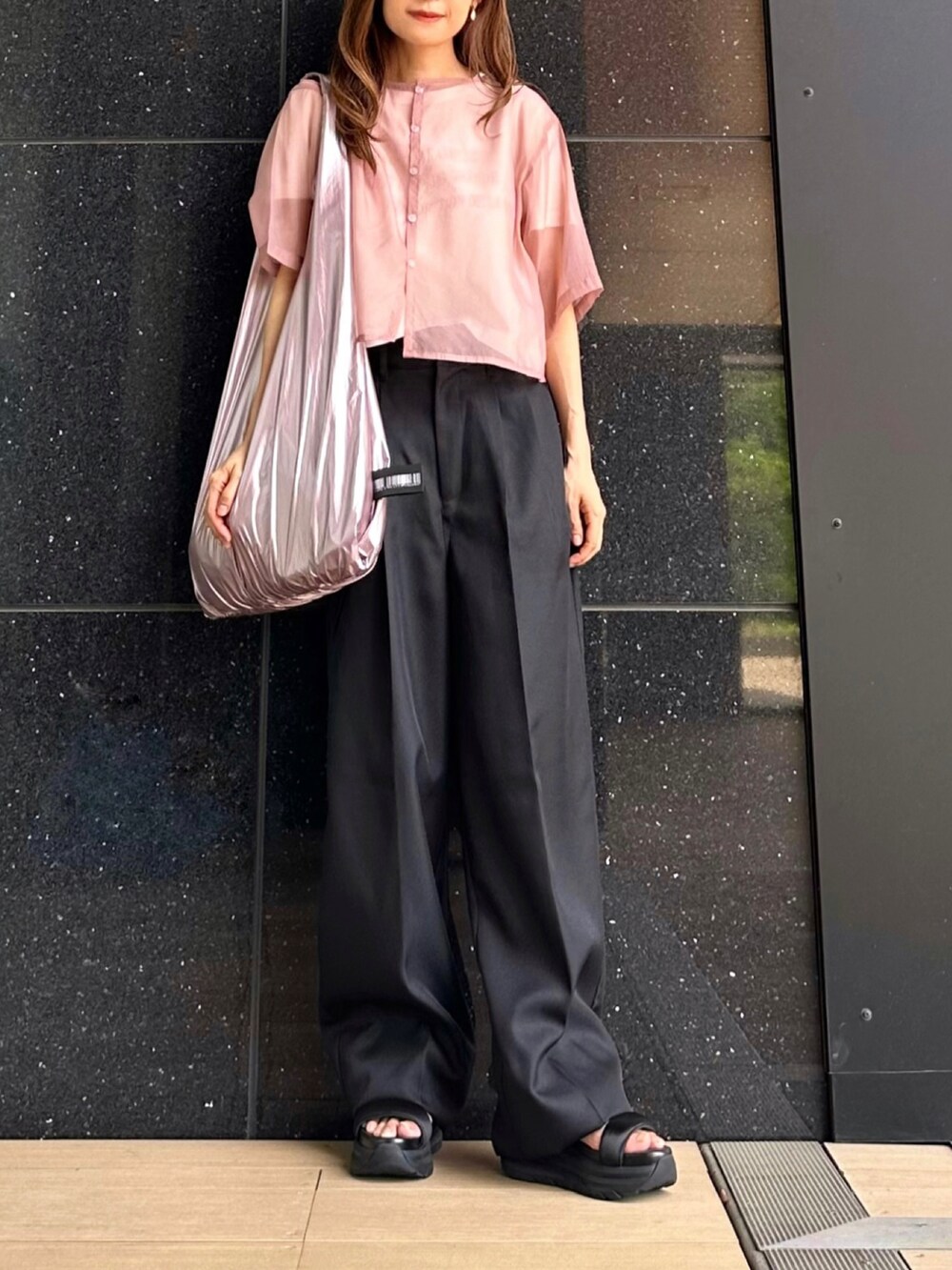 ブラック系のスラックス、ピンク系のシャツ/ブラウス、ホワイト系のTシャツ/カットソーを着用したレディースの夏コーディネートの3枚目の写真