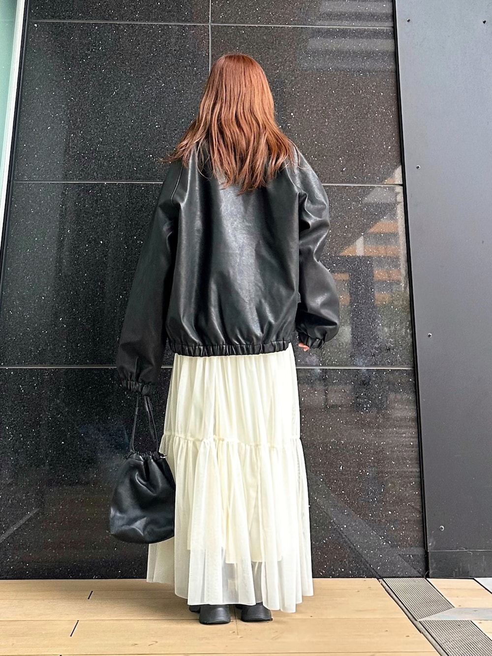 ブラック系のブルゾン、ブラック系のショルダーバッグ、ブラック系のブーツを着用したレディースの冬コーディネートの5枚目の写真