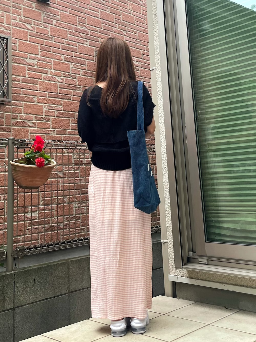 ブルー系のトートバッグ、ブラック系のニット/セーター、ピンク系のスカートを着用したレディースの夏コーディネートの2枚目の写真