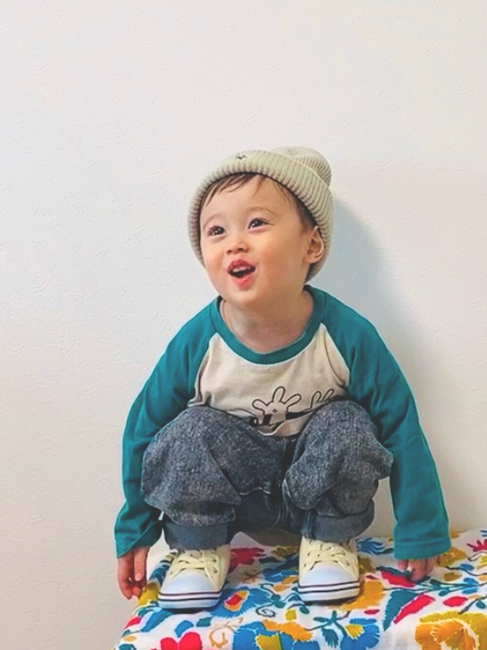 ホワイト系のスニーカー、ブラック系のデニムパンツ、ホワイト系のニットキャップ/ビーニーを着用したキッズの冬コーディネートの2枚目の写真