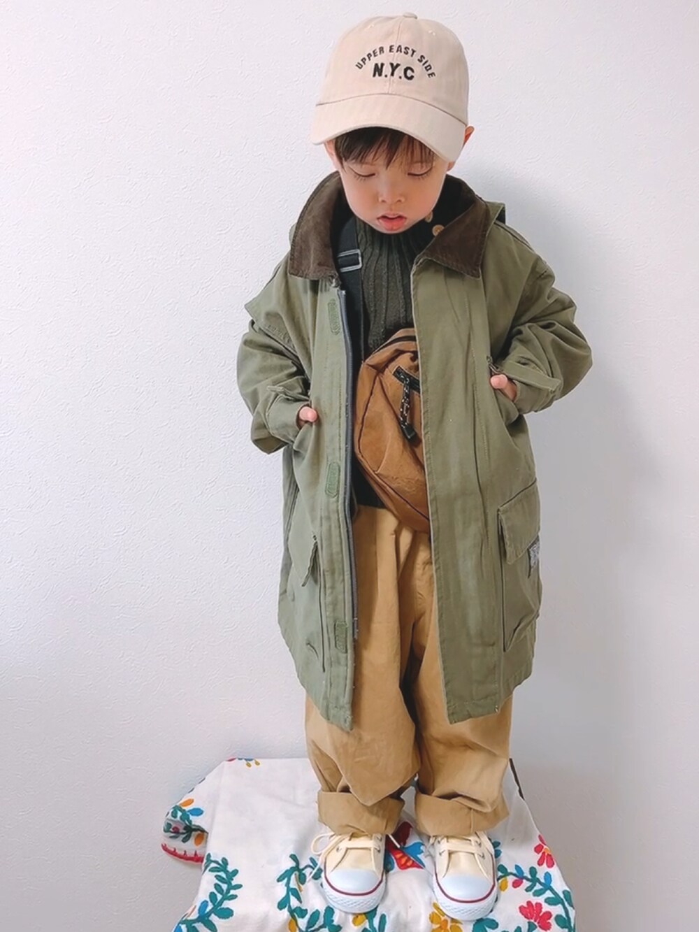 グリーン系のモッズコート、グリーン系のニット/セーター、ベージュ系のカーゴパンツを着用したキッズの冬コーディネートの2枚目の写真