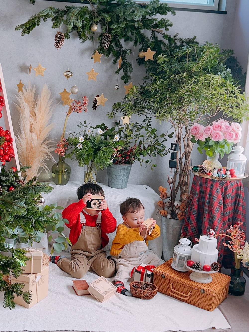 レッド系のニット/セーター、イエロー系のニット/セーター、ベージュ系のサロペット/オーバーオールを着用したキッズの冬コーディネートの2枚目の写真