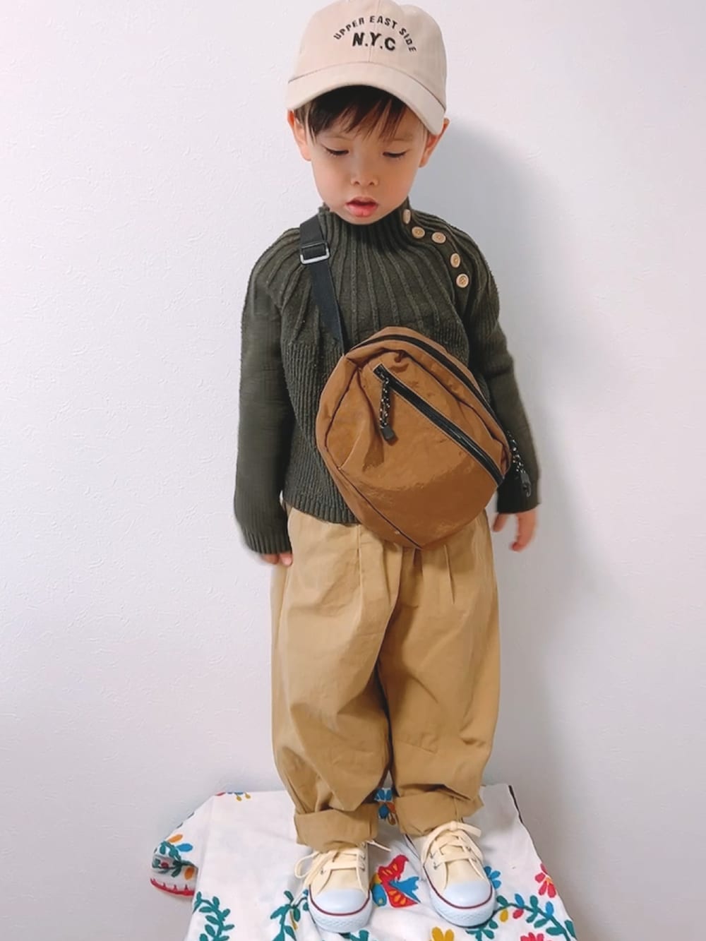 グリーン系のモッズコート、グリーン系のニット/セーター、ベージュ系のカーゴパンツを着用したキッズの冬コーディネートの3枚目の写真