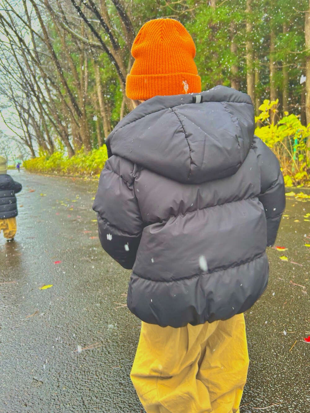 ブラック系のブルゾン、ベージュ系のカーゴパンツ、オレンジ系のニットキャップ/ビーニーを着用したキッズの冬コーディネートの2枚目の写真