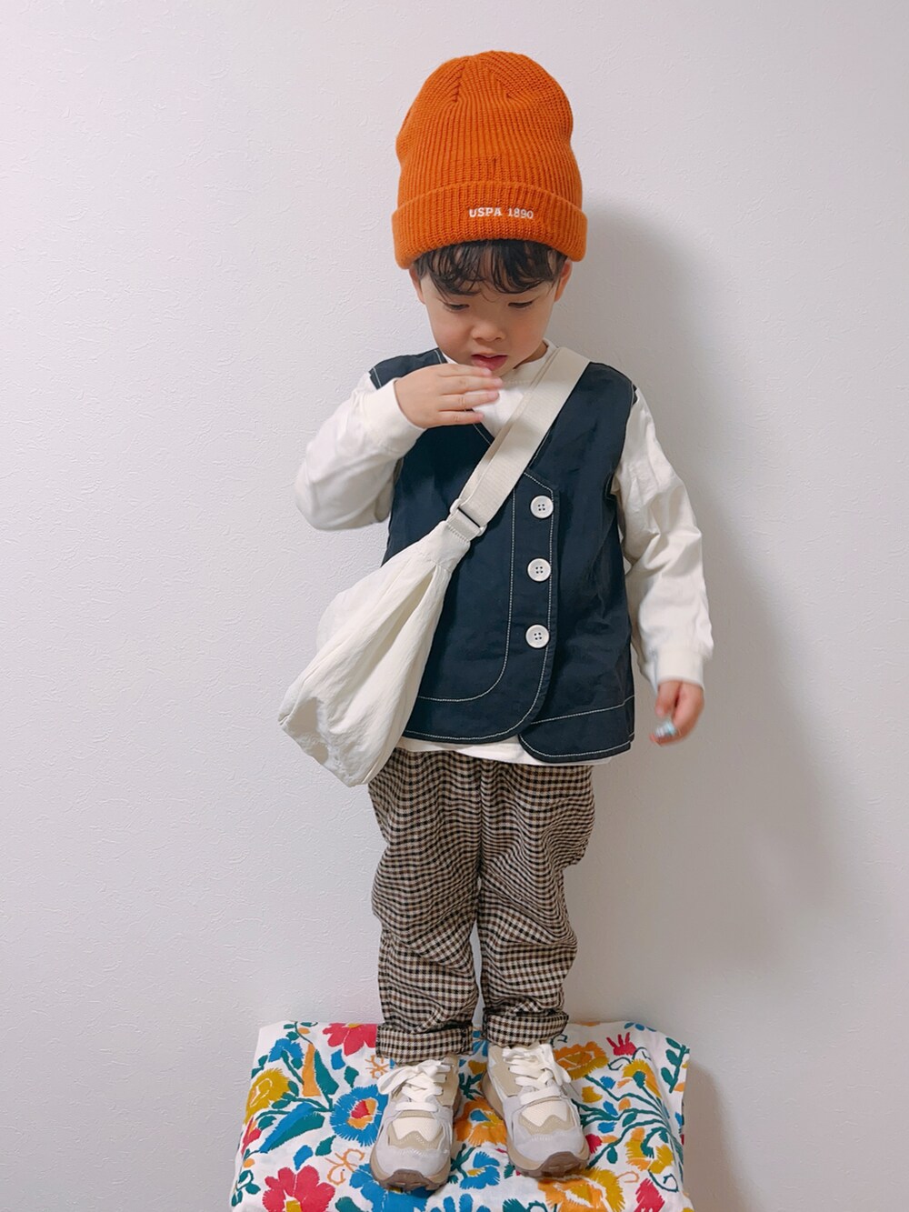 ブラック系のTシャツ/カットソー、ホワイト系のスニーカー、ホワイト系のショルダーバッグを着用したキッズの冬コーディネートの4枚目の写真