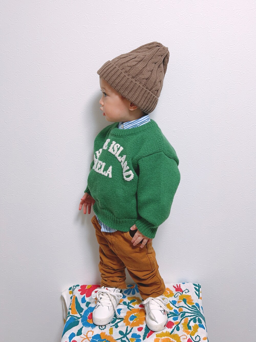 グリーン系のニット/セーター、ブルー系のシャツ/ブラウス、ブラウン系のチノパンツを着用したキッズの秋コーディネートの3枚目の写真