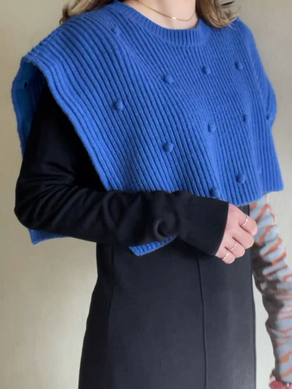 ブルー系のニット/セーター、ブラック系のワンピース/ドレスを着用したレディースの春コーディネートの4枚目の写真