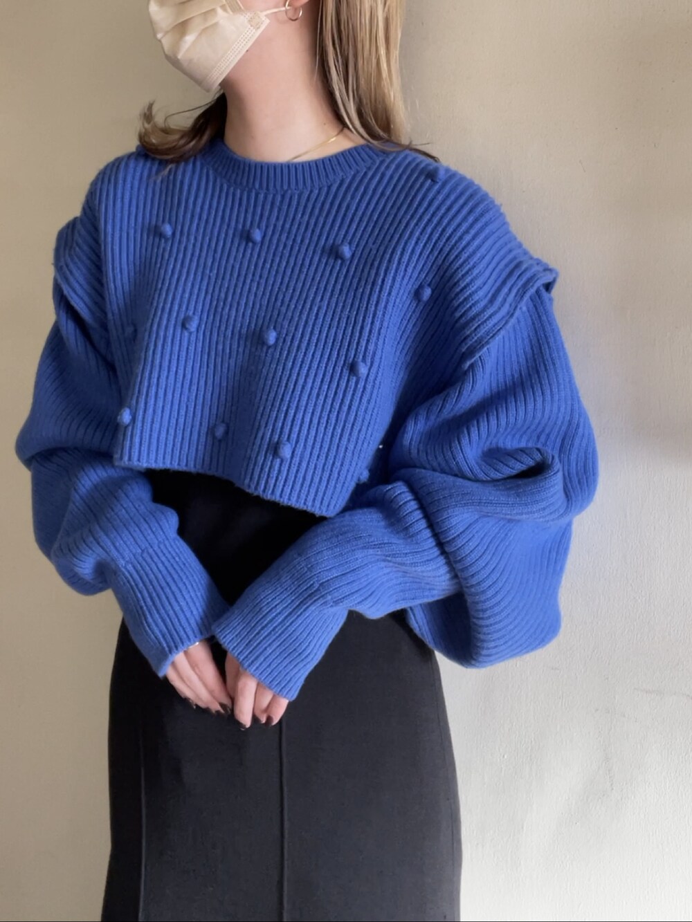 ブルー系のニット/セーター、ブラック系のワンピース/ドレスを着用したレディースの春コーディネートの2枚目の写真