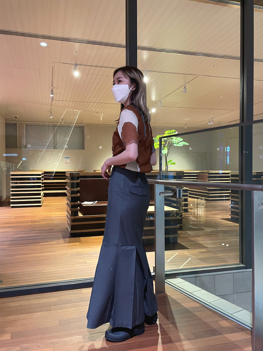 オレンジ系のシャツ/ブラウス、グレー系のスカートを着用したレディースの春コーディネートの3枚目の写真