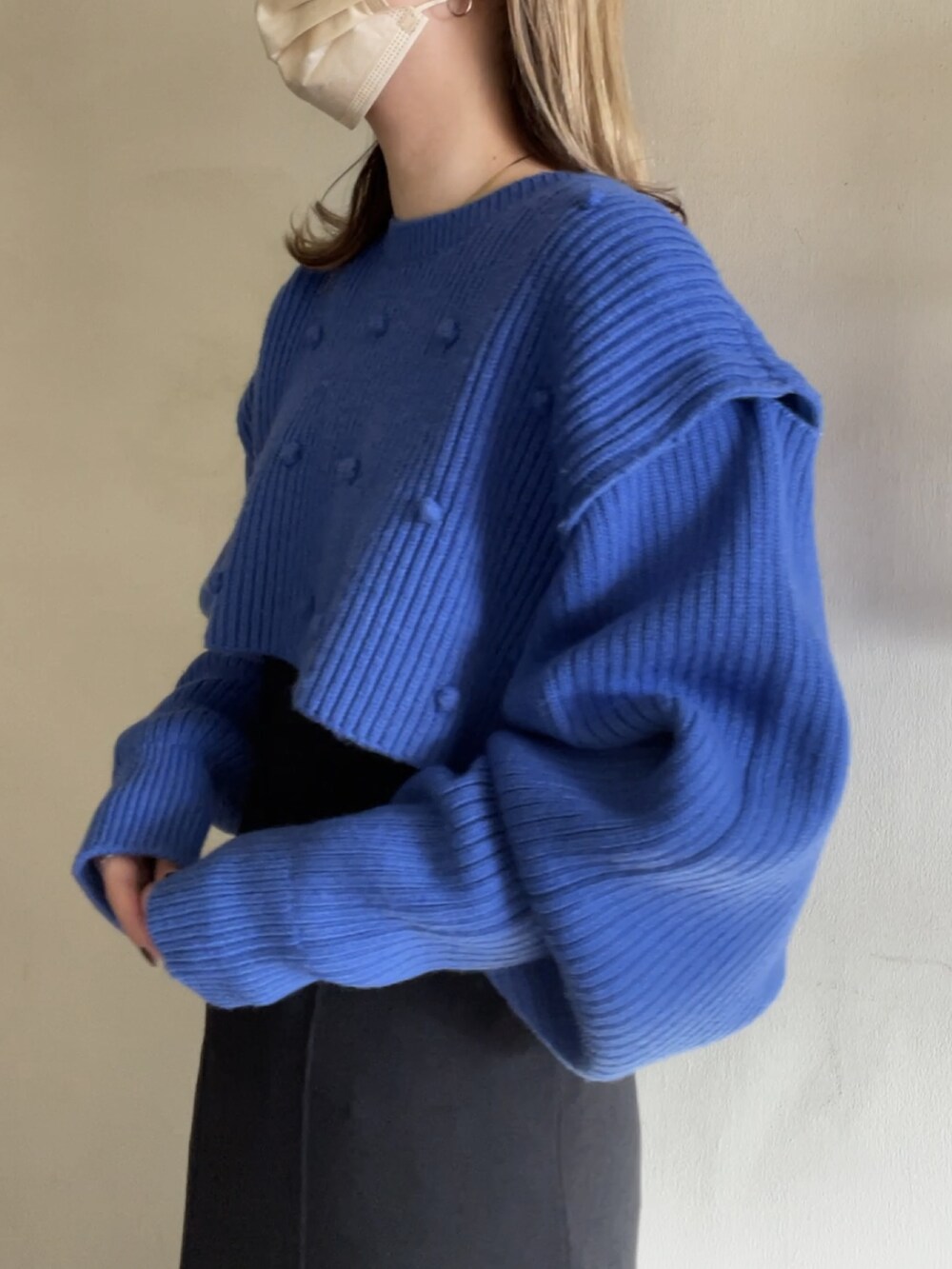 ブルー系のニット/セーター、ブラック系のワンピース/ドレスを着用したレディースの春コーディネートの3枚目の写真