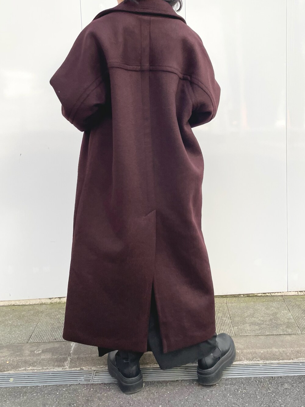 ブラック系のワンピース、レッド系のステンカラーコート、ブラウン系のニット/セーターを着用したレディースの冬コーディネートの4枚目の写真