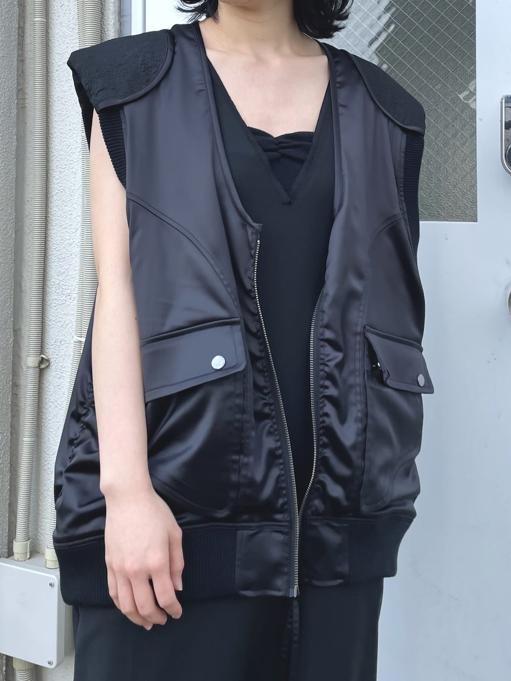 ブラック系のワンピース、ブラック系のベストを着用したレディースの春コーディネートの3枚目の写真