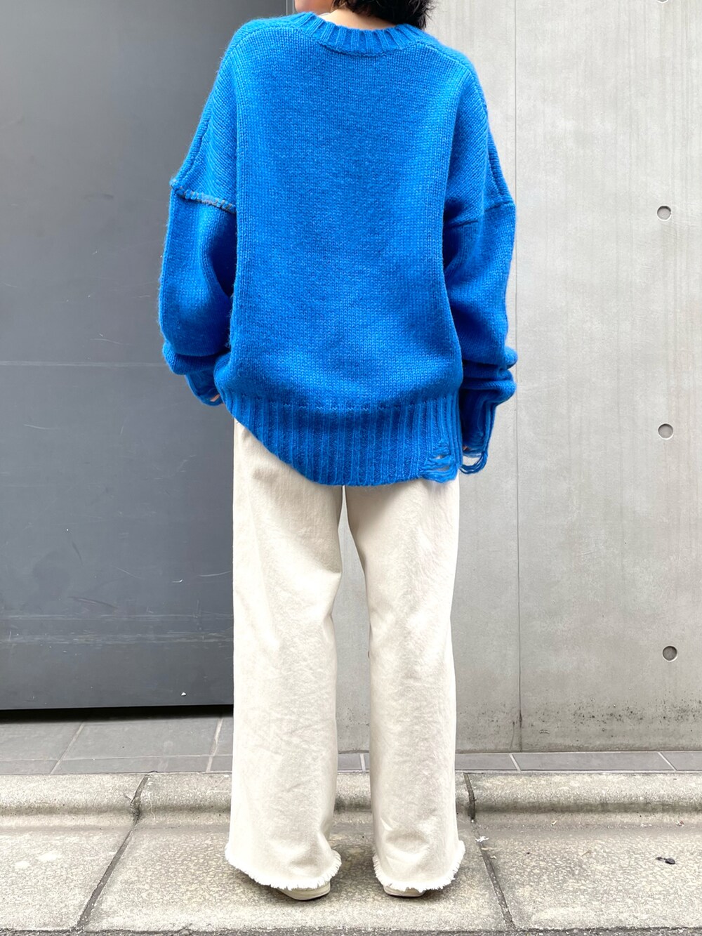 ブルー系のニット/セーターを着用したレディースの秋コーディネートの2枚目の写真