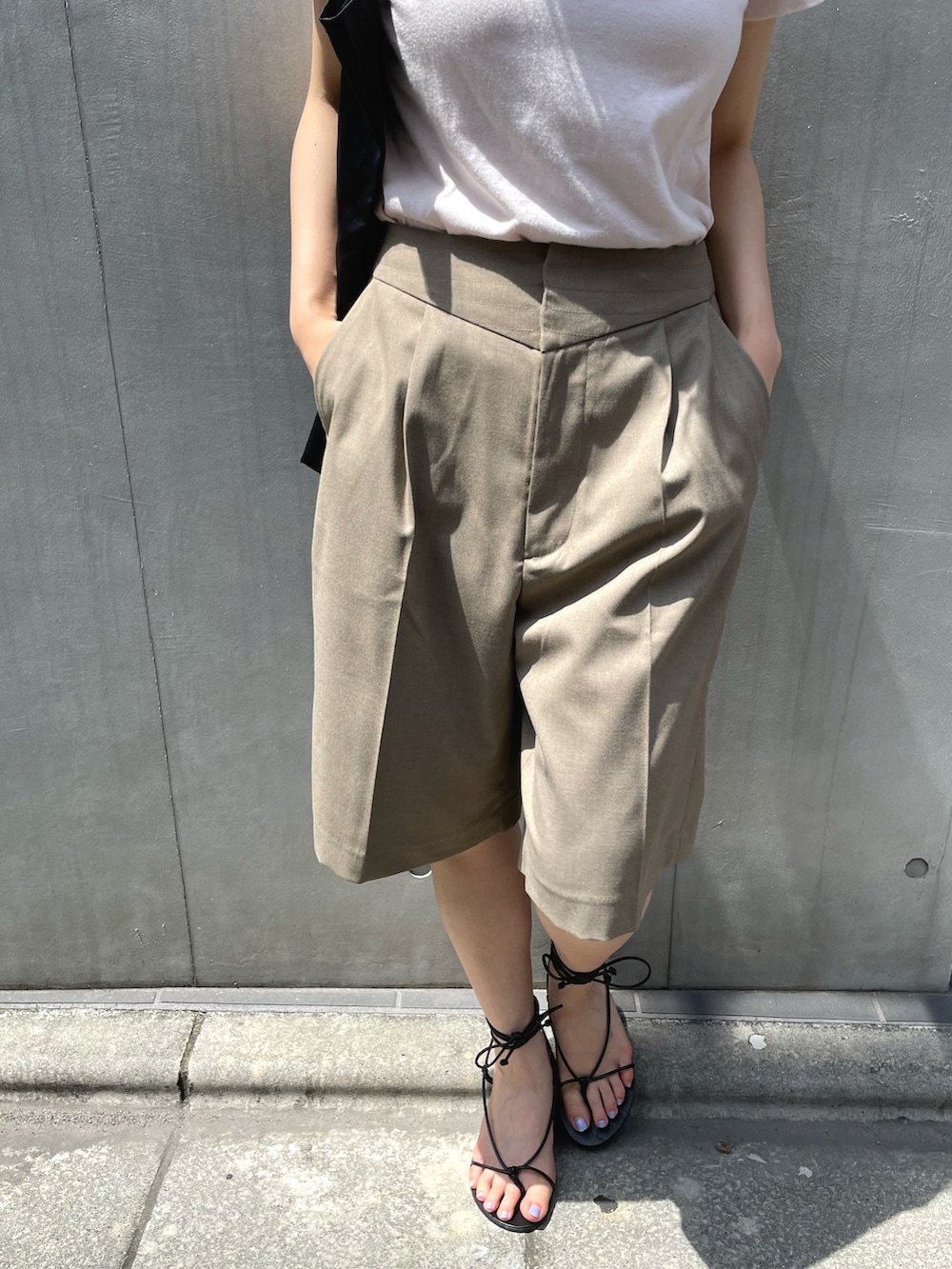 ブラック系のサンダル、ピンク系のTシャツ/カットソー、ベージュ系のその他パンツを着用したレディースの夏コーディネートの2枚目の写真