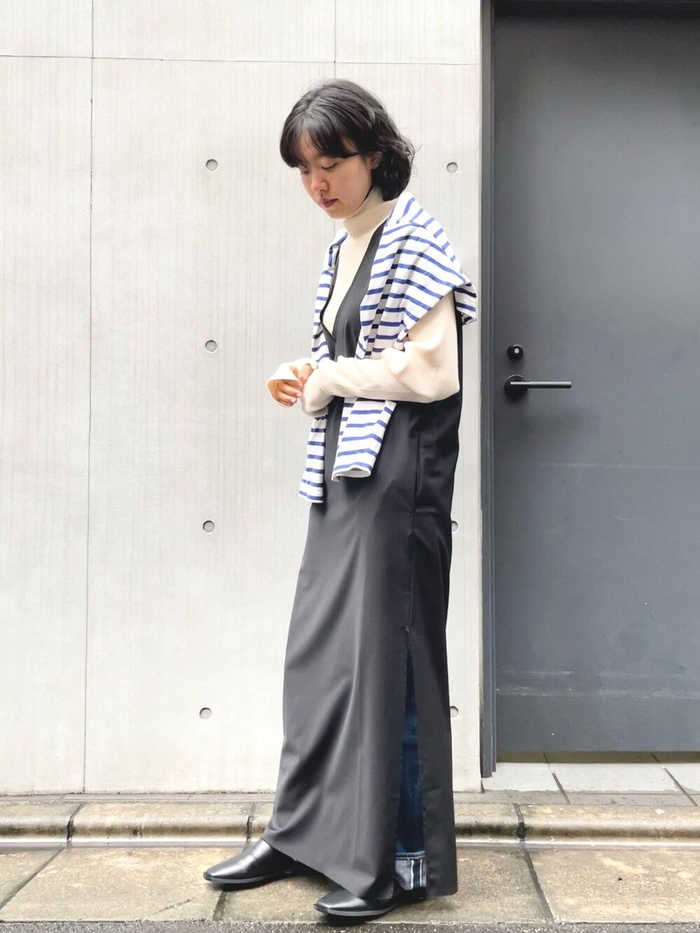 ブラック系のワンピース、ベージュ系のニット/セーターを着用したレディースの秋コーディネートの2枚目の写真