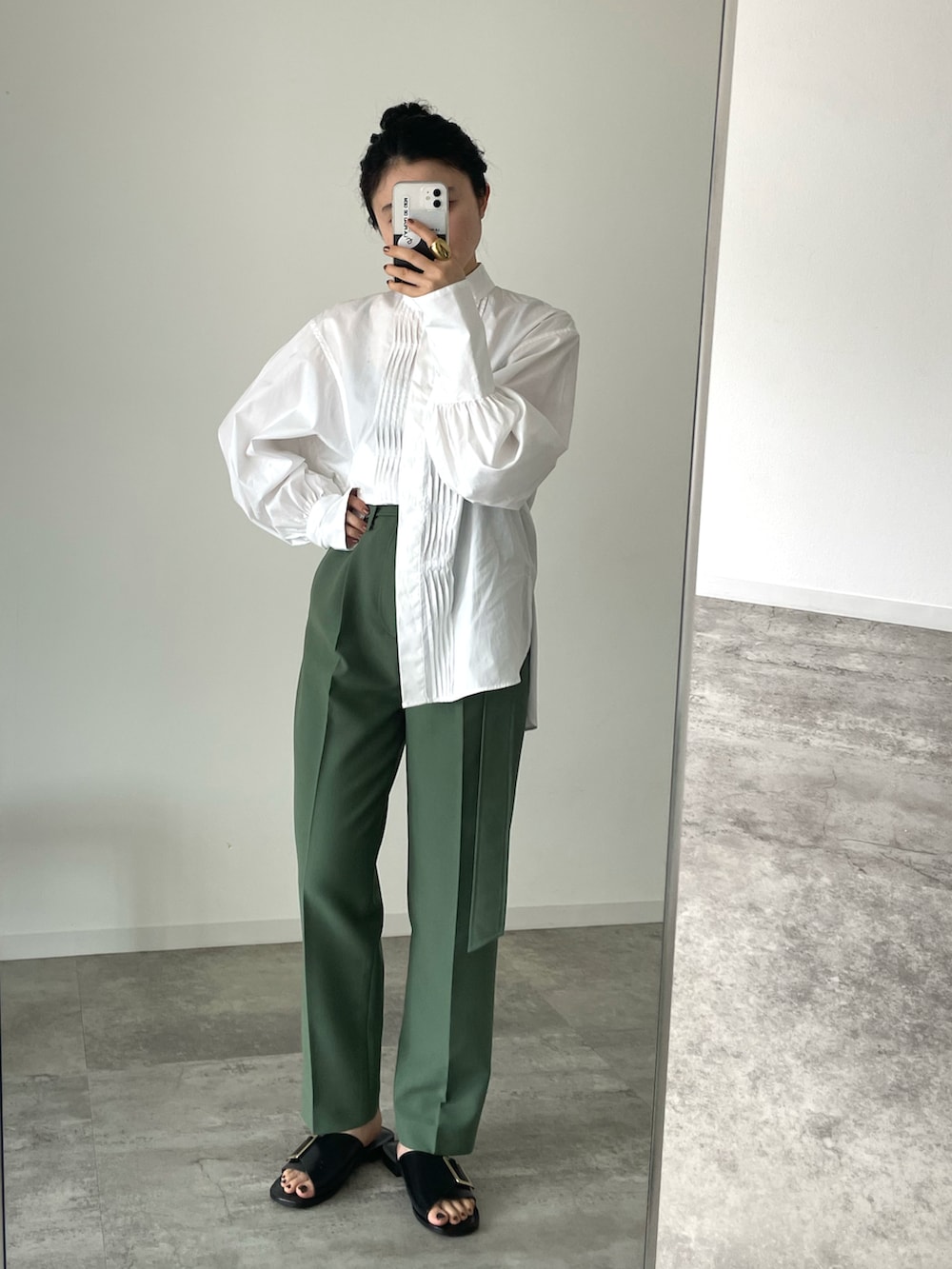 ホワイト系のシャツ/ブラウス、ブラック系のサンダル、グリーン系のスラックスを着用したレディースの春コーディネートの2枚目の写真