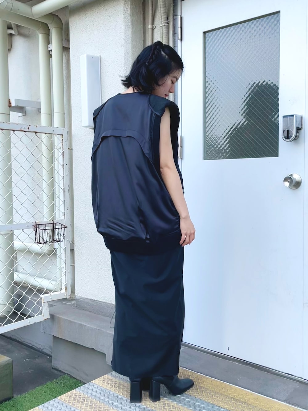 ブラック系のワンピース、ブラック系のベストを着用したレディースの春コーディネートの2枚目の写真