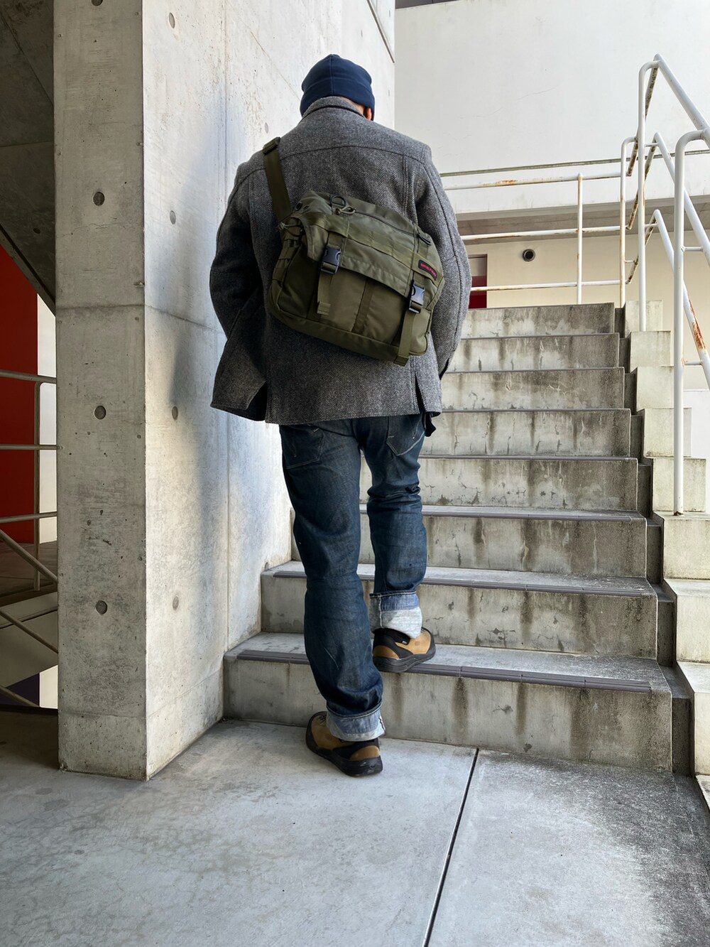 グレー系のテーラードジャケット、ブルー系のデニムパンツ、ブラウン系のブーツを着用したメンズの冬コーディネートの3枚目の写真