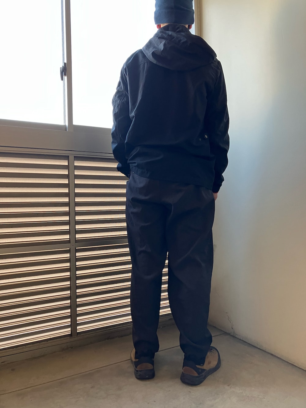 ブラック系のマウンテンパーカー、オレンジ系のシャツ/ブラウス、グレー系のその他パンツを着用したメンズの冬コーディネートの4枚目の写真