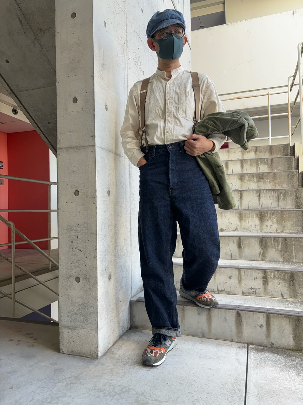 グリーン系のカバーオール、ブルー系のデニムパンツ、その他のスニーカーを着用したメンズの秋コーディネートの4枚目の写真