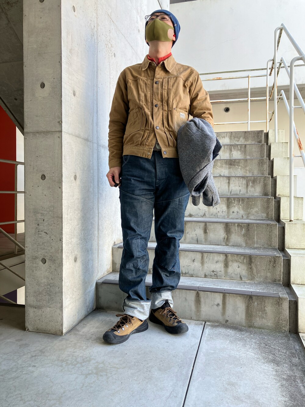 グレー系のテーラードジャケット、ブルー系のデニムパンツ、ブラウン系のブーツを着用したメンズの冬コーディネートの4枚目の写真