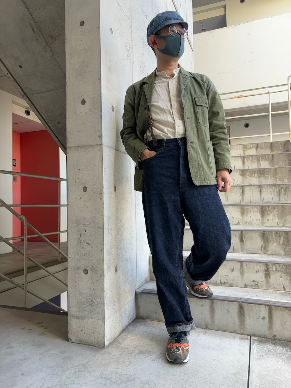 グリーン系のカバーオール、ブルー系のデニムパンツ、その他のスニーカーを着用したメンズの秋コーディネートの3枚目の写真