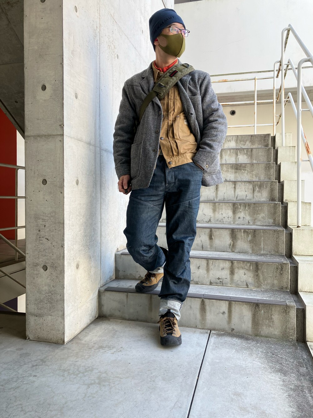 グレー系のテーラードジャケット、ブルー系のデニムパンツ、ブラウン系のブーツを着用したメンズの冬コーディネートの2枚目の写真