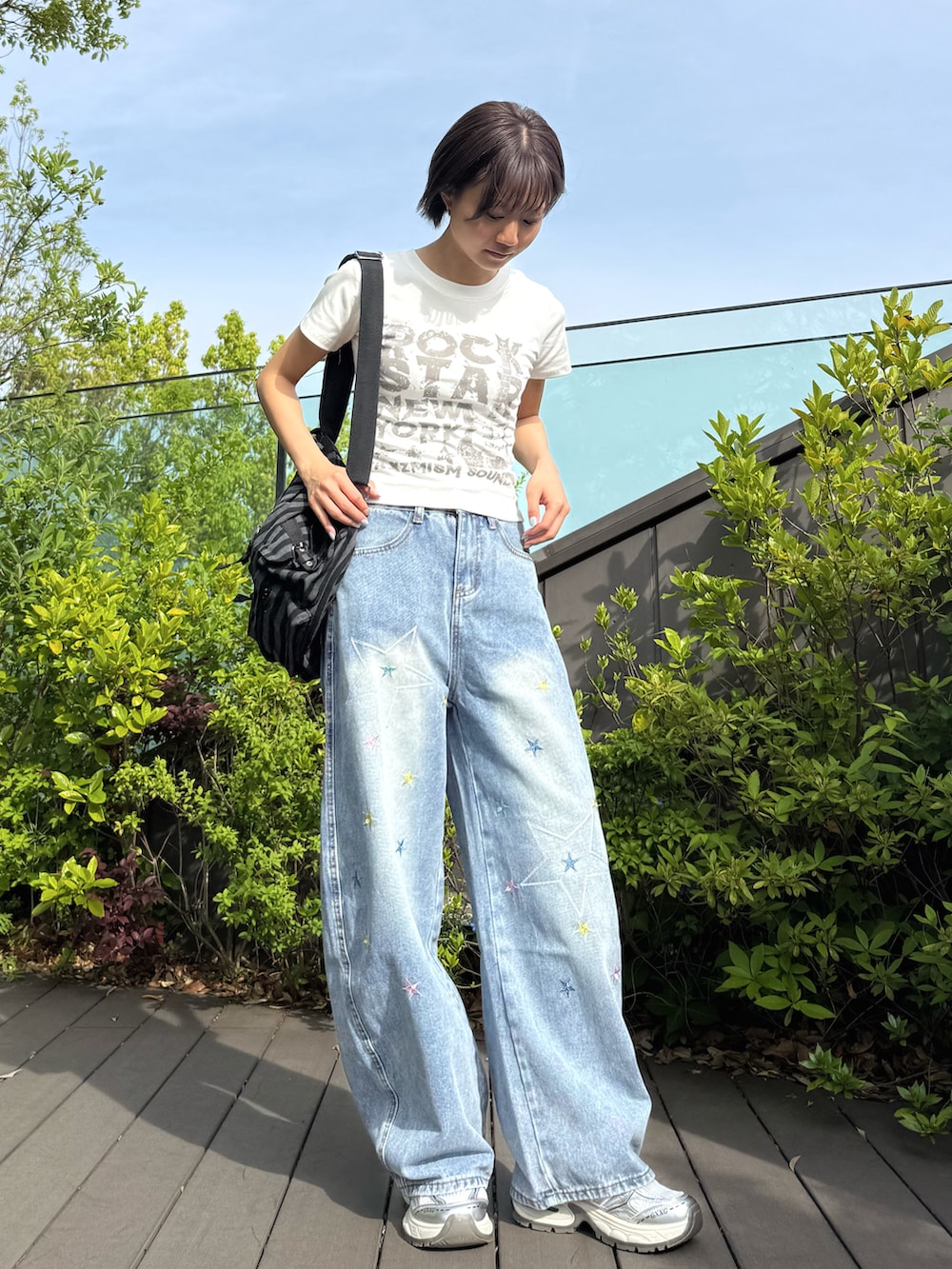 ホワイト系のTシャツ/カットソー、ブルー系のデニムパンツ、ブラック系のバックパック/リュックを着用したレディースの春コーディネートの2枚目の写真