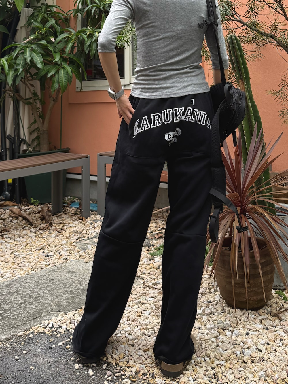 グレー系のTシャツ/カットソー、ブラック系のスウェットパンツ、ブラック系のバックパック/リュックを着用したレディースの秋コーディネートの2枚目の写真