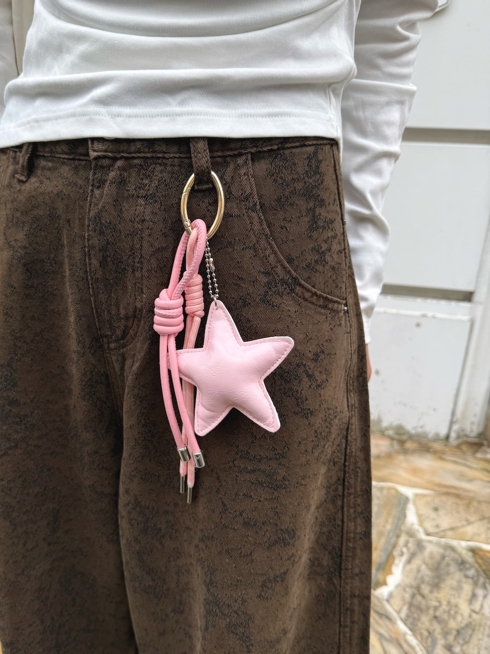 ホワイト系のTシャツ/カットソー、ブラウン系のデニムパンツ、ホワイト系のショルダーバッグを着用したレディースの秋コーディネートの3枚目の写真
