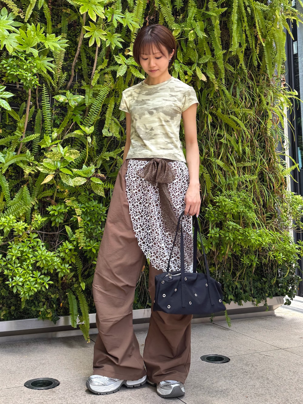 グリーン系のTシャツ/カットソー、ブラウン系のその他パンツ、ブラック系のショルダーバッグを着用したレディースの春コーディネートの4枚目の写真