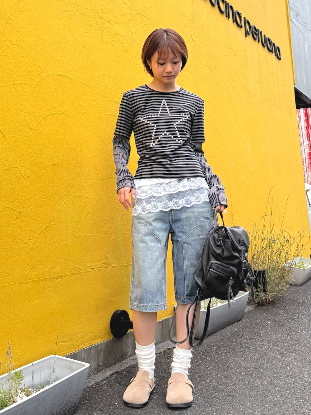 グレー系のTシャツ/カットソー、ブルー系のデニムパンツ、ホワイト系のスカートを着用したレディースの春コーディネートの3枚目の写真